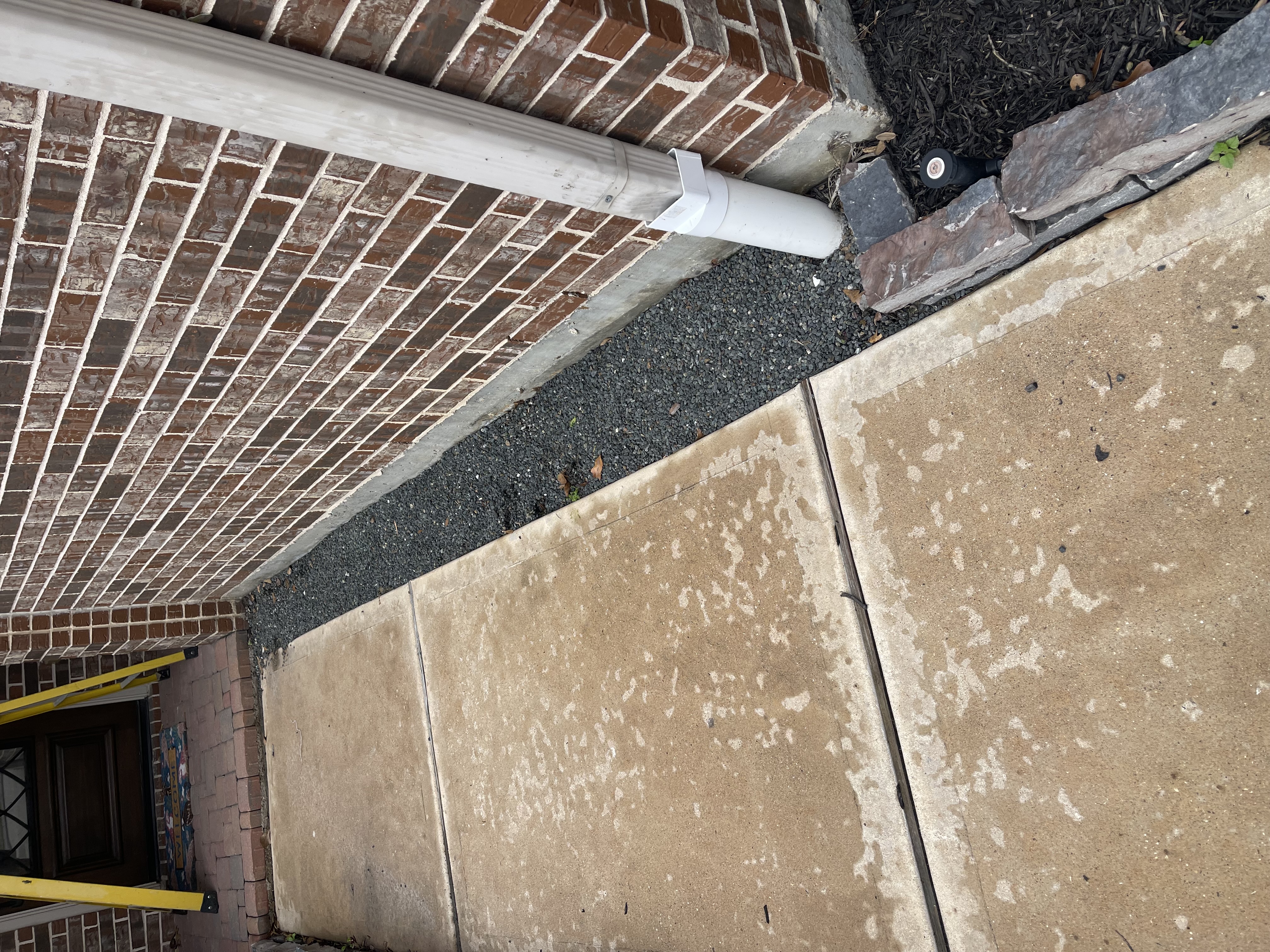 Downspout extension and underground pipe connection for landscape drainage in Cypress, TX